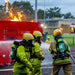 Firefighters with ba gear in training with a fire burning behind them